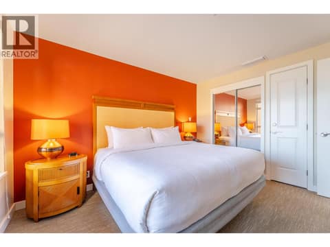 Furnished bedroom with warm feature wall and built-in closet. at 15 PARK Place Unit# 209, Osoyoos