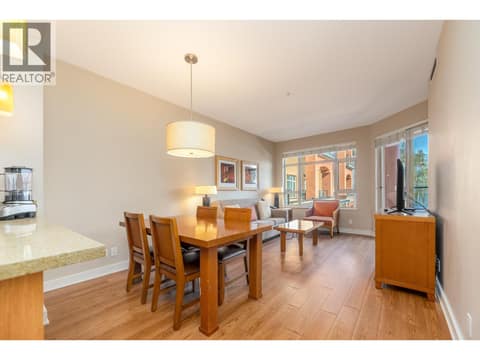 Furnished dining and living area with natural light and balcony access. at 15 PARK Place Unit# 209, Osoyoos