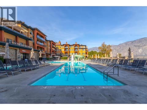 Outdoor pool with waterslide and resort buildings. at 15 PARK Place Unit# 209, Osoyoos