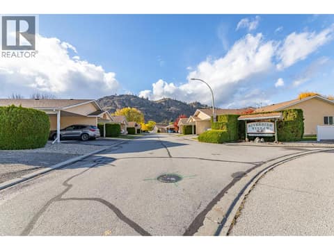 Community streetscape view shows the residential layout and surrounding hills. at 145 REDWING Place Unit# 7, Oliver