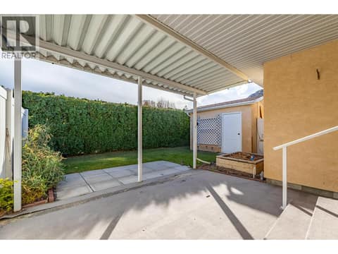 Covered patio view showing the back steps, garden bed and yard. at 145 REDWING Place Unit# 7, Oliver