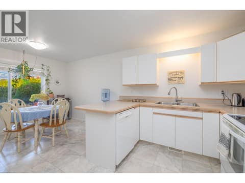 Kitchen workspace with wraparound counters and an open connection to dining. at 145 REDWING Place Unit# 7, Oliver