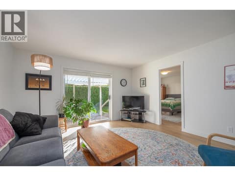 Living room view emphasizes the direct connection to the patio and bedroom hall. at 145 REDWING Place Unit# 7, Oliver