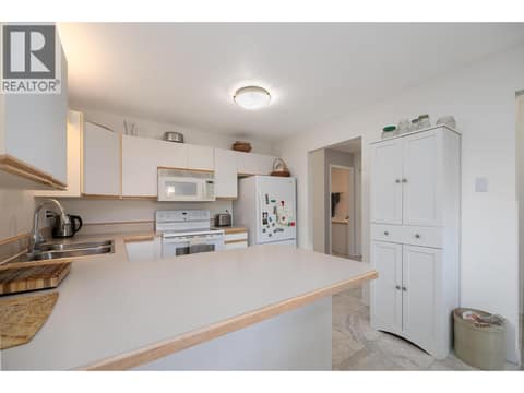 Peninsula counter provides additional kitchen preparation space. at 145 REDWING Place Unit# 7, Oliver