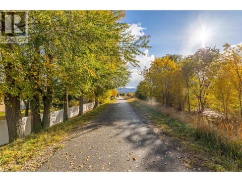 Tree-lined path offers a scenic view of the area beyond the property. at 145 REDWING Place Unit# 7, Oliver